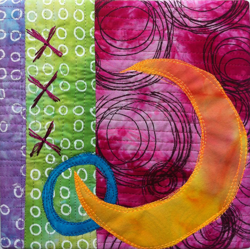 textile art with orange crescent surrounded by pink, green, and purple circles and embroidered X