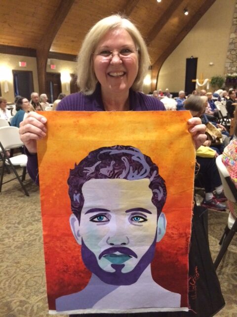 Playful Portraiture Student Bearded Man woman holding portrait made in fabric of bearded man